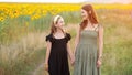 Mother and daughter show love smiling against sunflowers