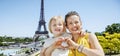 Mother and daughter showing heart shaped hands in Paris, France