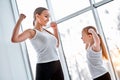 Mother and daughter showing strong hands in gym