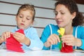 Mother and daughter sit and make artificial flower Royalty Free Stock Photo