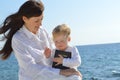 Mother and daughter sitting on the beach holding the Bible