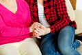 Mother and daughter sitting on couch and holding hands Royalty Free Stock Photo