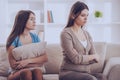 Mother and daughter sitting on couch after quarrel