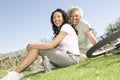 Mother And Daughter Sitting On Grass In Park Royalty Free Stock Photo