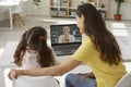 Mother and daughter sitting at laptop computer and having class with online teacher Royalty Free Stock Photo