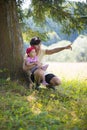 Mother and daughter sitting near a tree Royalty Free Stock Photo