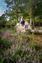 Mother and daughter sitting on a rock in pine forest, Wicklow Mountains, Ireland