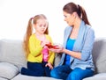 Mother and daughter sitting on sofa eating apple. Royalty Free Stock Photo