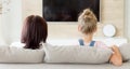 Mother and daughter sitting on sofa and watching tv, Family time concept, back view Royalty Free Stock Photo