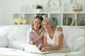 Mother and daughter sitting at table with laptop, at home Royalty Free Stock Photo