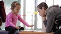 Mother and daughter sitting in waiting hall at airport with exercise book