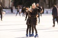 Mother and daughter skateing on ice.