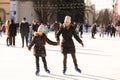 Mother and daughter skateing on ice.