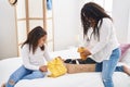 Mother and daughter smiling confident folding clothes to donate at bedroom Royalty Free Stock Photo