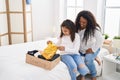 Mother and daughter smiling confident folding clothes to donate at bedroom Royalty Free Stock Photo