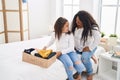 Mother and daughter smiling confident folding clothes to donate at bedroom Royalty Free Stock Photo