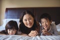 Mother with daughter and son relaxing on bed in bed room Royalty Free Stock Photo