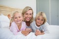 Mother with daughter and son relaxing on bed in the bedroom Royalty Free Stock Photo