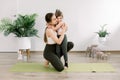 Mother and daughter spending time together doing yoga exercise home. Pretty woman and little child girl, hugging each Royalty Free Stock Photo