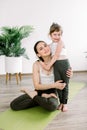 Mother and daughter spending time together doing yoga exercise at yoga studio. Pretty woman and little child girl Royalty Free Stock Photo