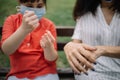 Mother and daughter spreading hand sanitizer on their hands outdoor