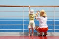 Mother and daughter standing on deck of yacht