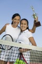 Mother and daughter standing on tennis court