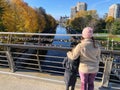 A mother and daughter standing together side by side on the corktown footbridge, admiring the beautiful autumn views Royalty Free Stock Photo