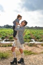 Mother and daughter standing in a vast meadow, the woman cradling the little girl in her arms.