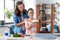 mother and daughter sticking masking tape to table