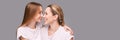 Mother and daughter studio portrait. Grey background. Smiling people