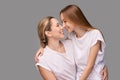 Mother and daughter studio portrait. Grey background. Smiling people