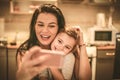 Mother and daughter take a self portrait using smart phone. Royalty Free Stock Photo