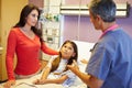 Mother And Daughter Talking To Consultant In Hospital Room