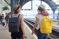 Mother and daughter teenager with backpacks suitcase walking in train station