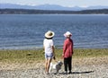 Mother, daughter and their dog looking out into Puget sound with Olympic mountains visible Royalty Free Stock Photo