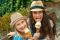 Mother and daughter sitting at bench and eating ice cream Royalty Free Stock Photo