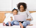 Mother and daughter typing on laptop Royalty Free Stock Photo