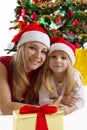 Mother and daughter under Christmas tree Royalty Free Stock Photo