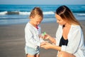 Mother and daughter use an antiseptic on the beach