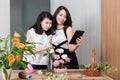 Mother and daughter using digital tablet while arranging flowers Royalty Free Stock Photo