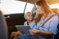 Mother and daughter using digital tablet in car Royalty Free Stock Photo