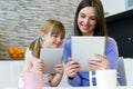 Mother and daughter using a digital tablet in kitchen Royalty Free Stock Photo