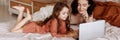 Mother and daughter using laptop on bed in holiday at home. Royalty Free Stock Photo