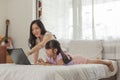 Mother and daughter using laptop on bed in holiday at home Royalty Free Stock Photo