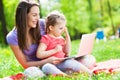 Mother and daughter using laptop outdoors Royalty Free Stock Photo