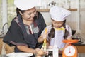 Mother and daughter using whisk to mix egg and wheat flour Royalty Free Stock Photo