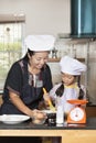 Mother and daughter using whisk to mix egg and wheat flour Royalty Free Stock Photo