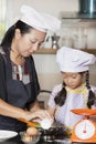 Mother and daughter using whisk to mix egg and wheat flour Royalty Free Stock Photo