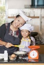 Mother and daughter using whisk to mix egg and wheat flour Royalty Free Stock Photo